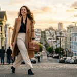 Woman holding leather clutch bag on hilly San Francisco street.
