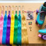 Colorful skating ribbons laid out next to a pair of skates.